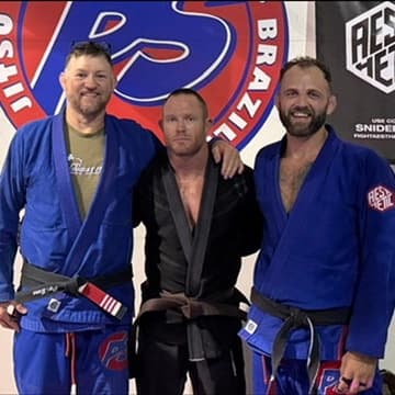 Four people in gis on the mats