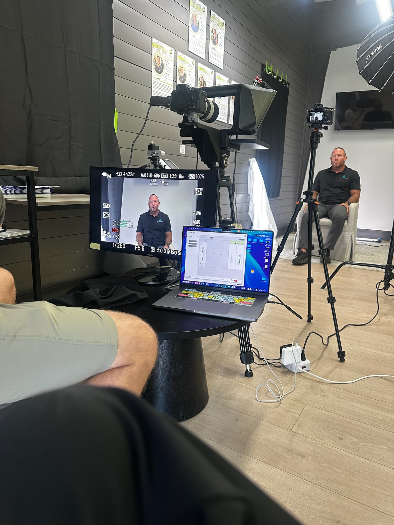 Chris seated in a studio with a camera